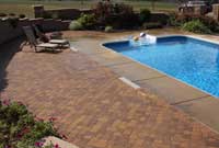 Paver patio with pool surrounded by retaining wall and privacy concrete two sided fence Paver patio with pool surrounded by retaining wall and privacy concrete two sided fence